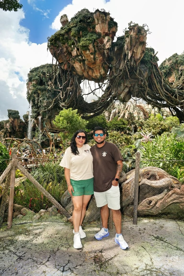 Couple posing for photo in front of ancient rock formation with large natural arch at theme park